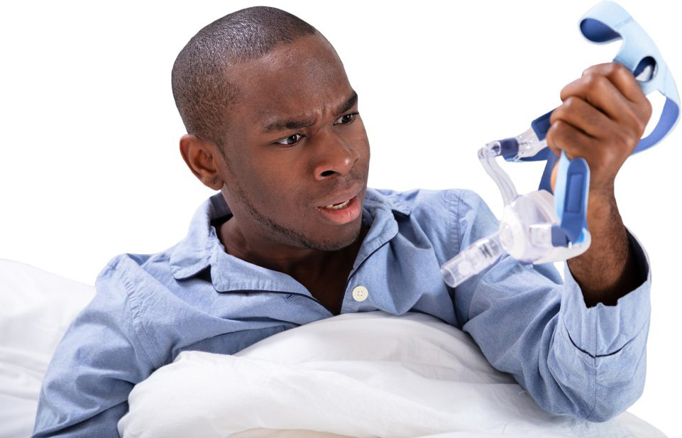Frustrated man holding a CPAP mask