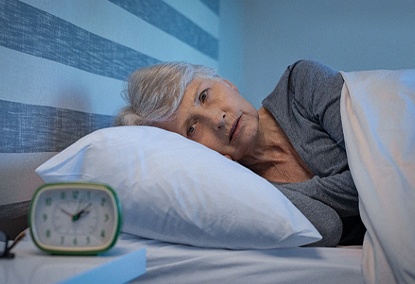 Woman awake in middle of night, experiencing insomnia