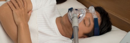 Man sleeping with CPAP mask for sleep apnea
