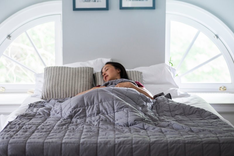 woman sleeping with a weighted blanket